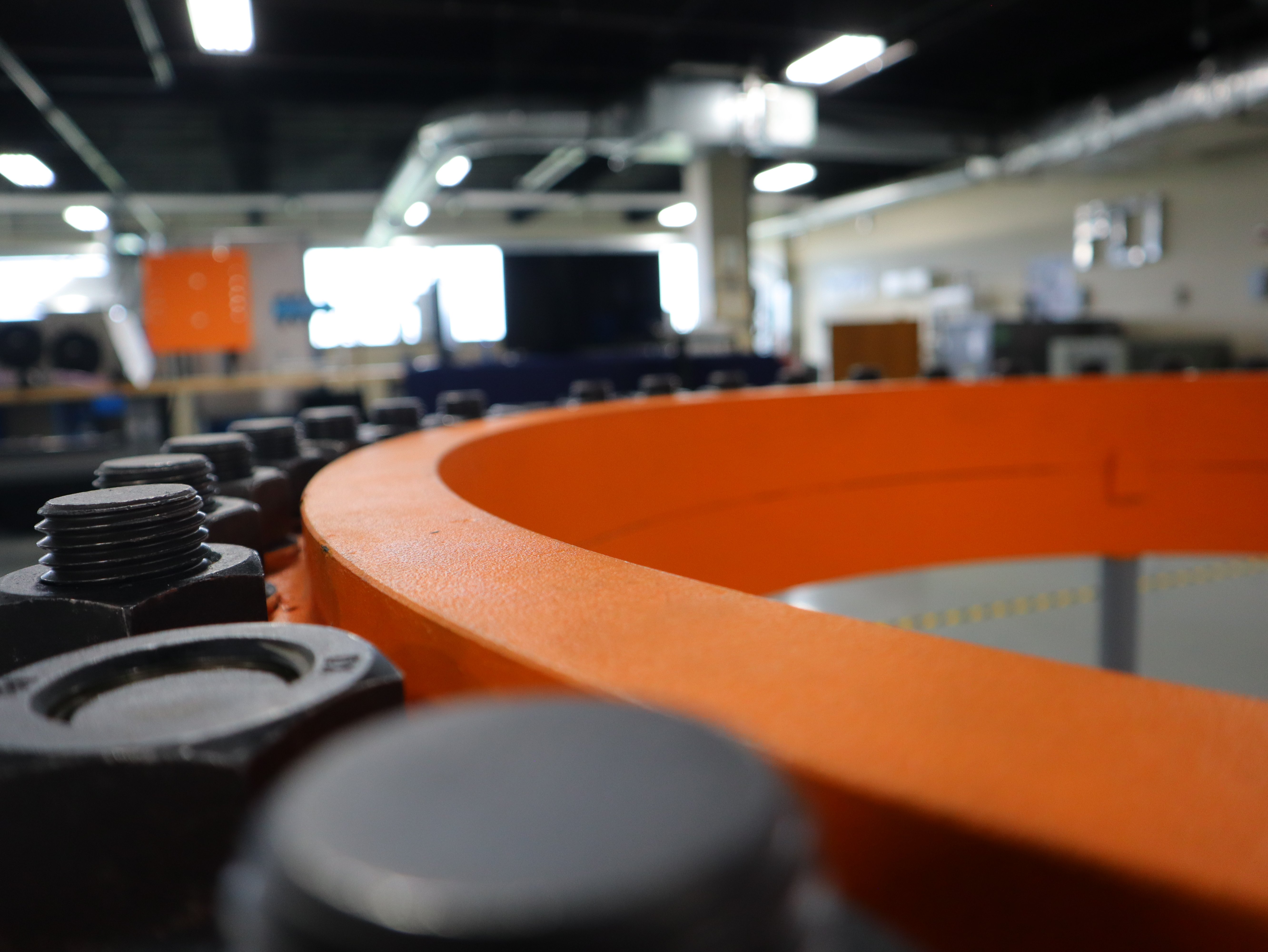 Close-up of industrial bolts and orange flange used in Pinnacle Career Institute’s GWO Bolt Tightening training, teaching wind technicians proper torque techniques for wind turbine safety.