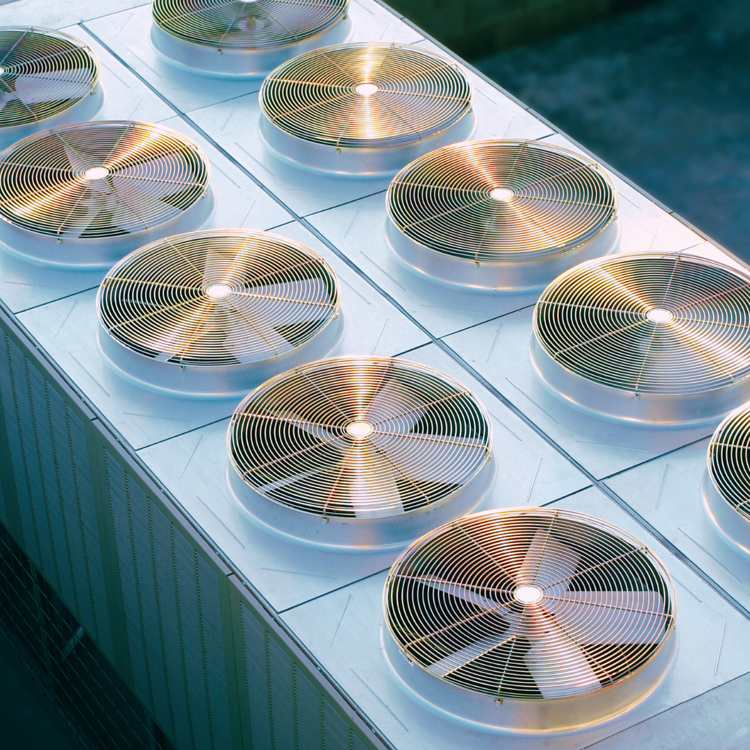 Close-up of multiple rooftop HVAC condenser fans used for cooling systems in commercial buildings.
