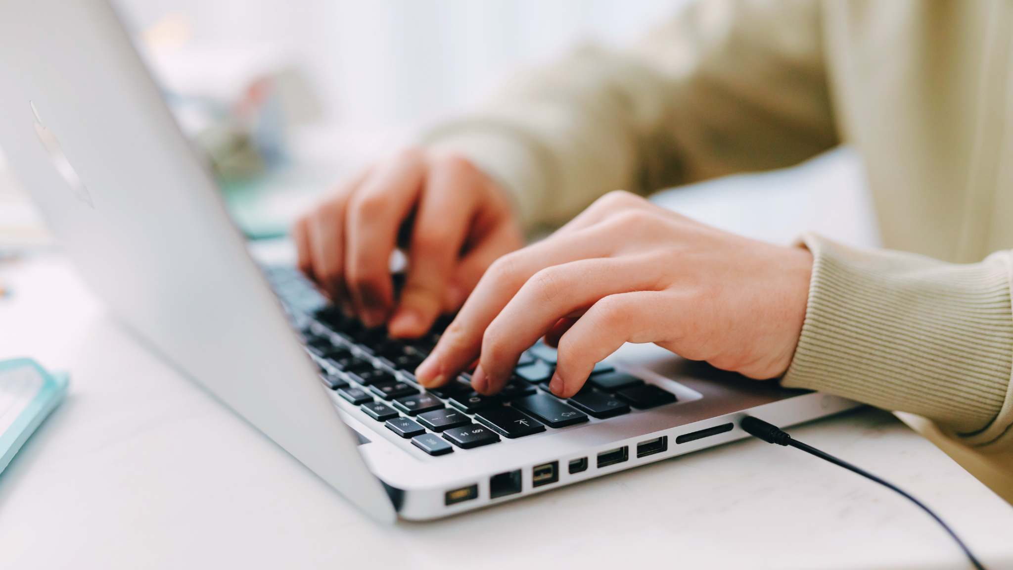 Student typing on a laptop while completing online coursework.